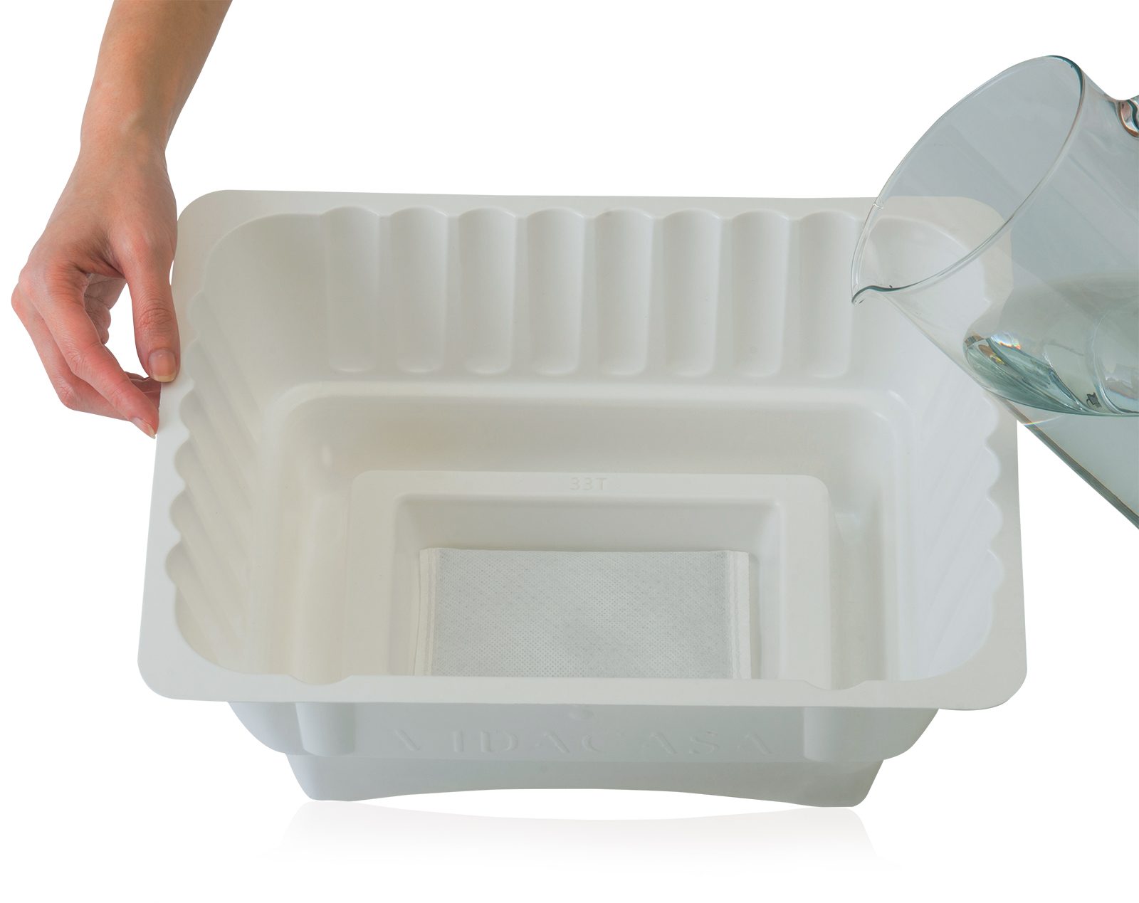 Pouring water into a white GN 1/2 base tray to activate the Heat Blaster