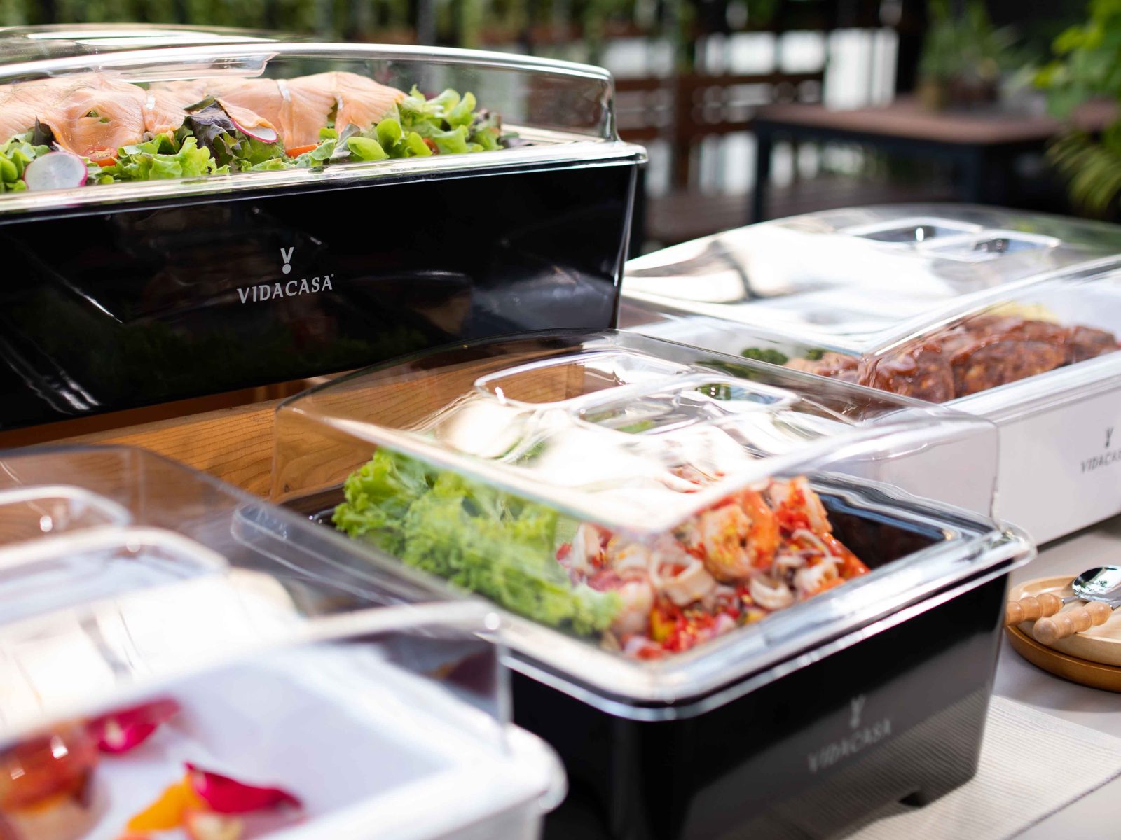 Classic sets in black and white with salad and roast meats on a garden terrace