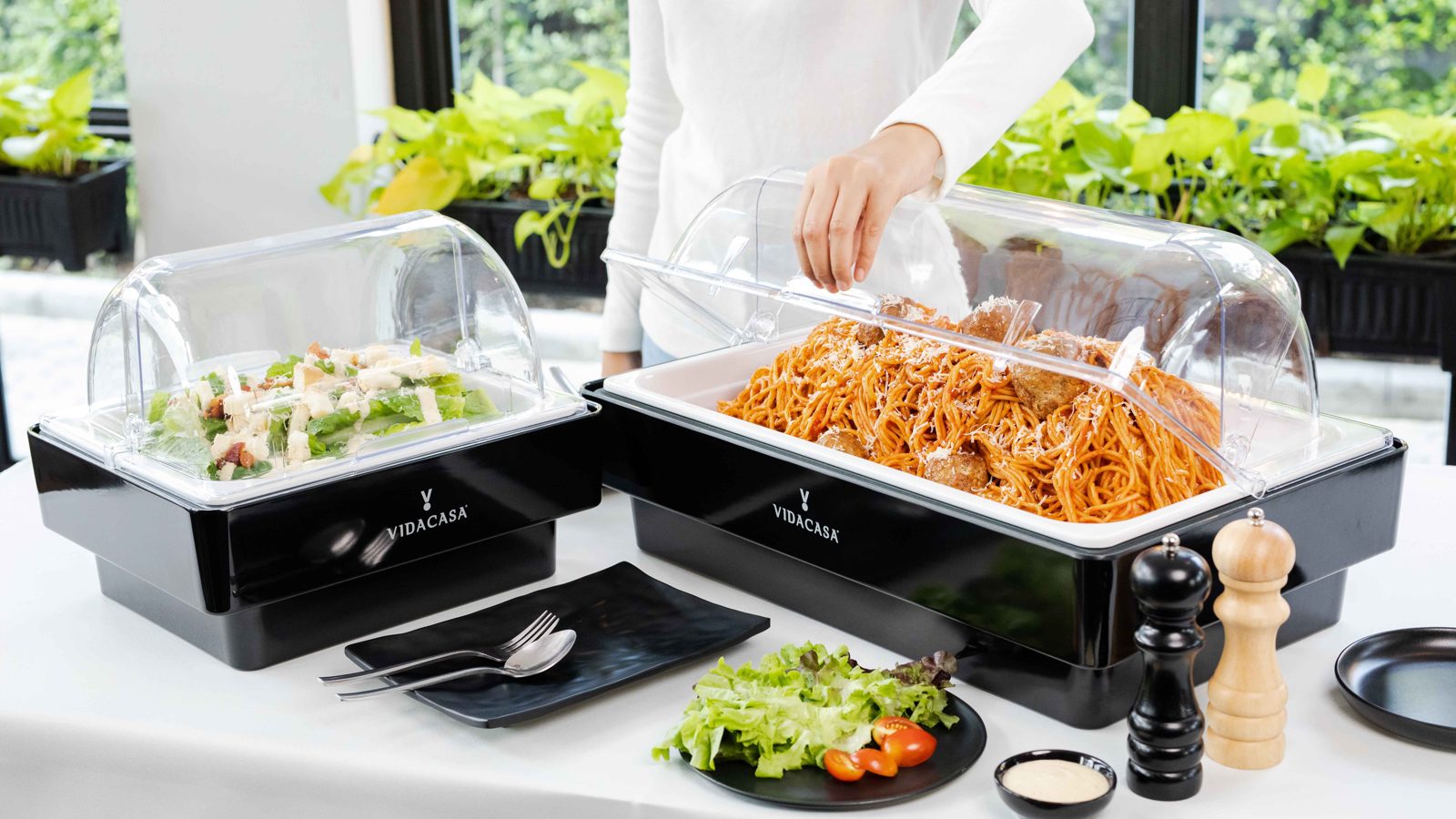 Hand placing a food pan onto a black Universal set with a cold cell visible